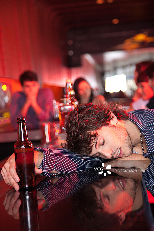 男人在夜总会的吧台上昏倒图片素材