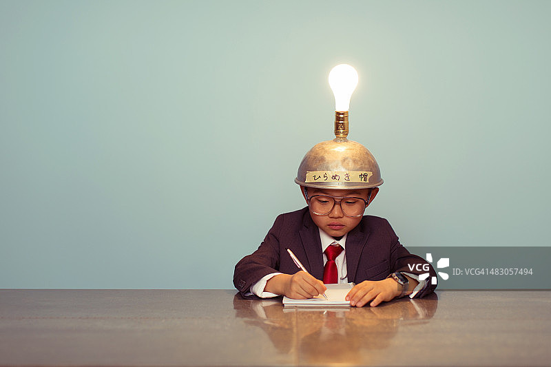 戴着发光思考帽的日本小商务男孩图片素材