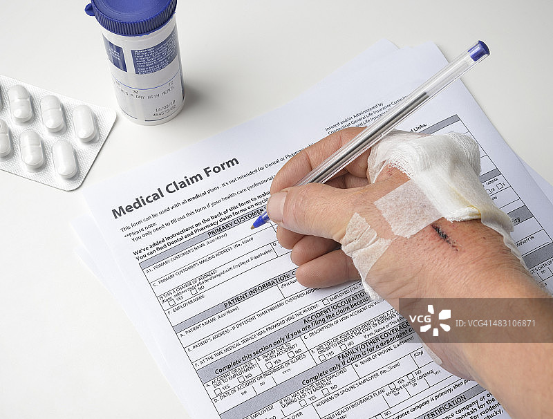 受伤的手填写医疗索赔表图片素材