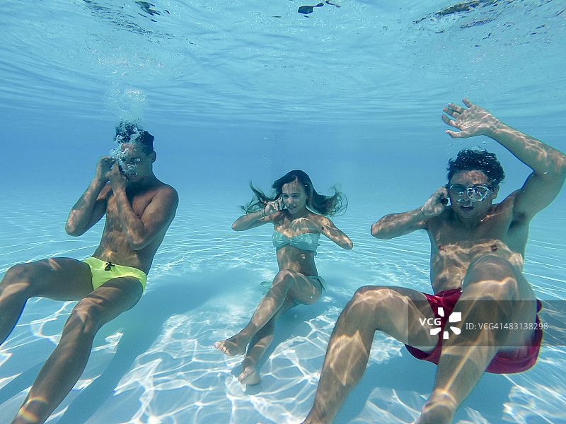朋友们在水下使用智能手机图片素材