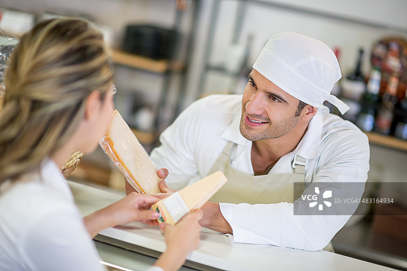 男人在熟食店与顾客交谈图片素材