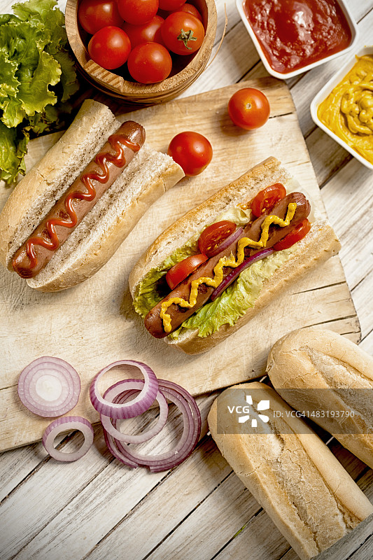 木桌上的番茄酱、芥末和热狗图片素材
