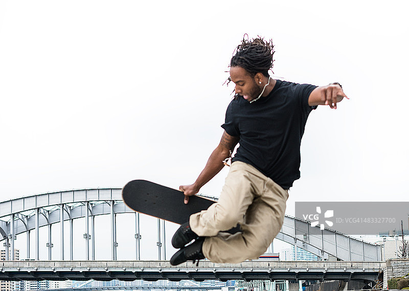 快乐的非洲男人滑冰和做一些技巧图片素材