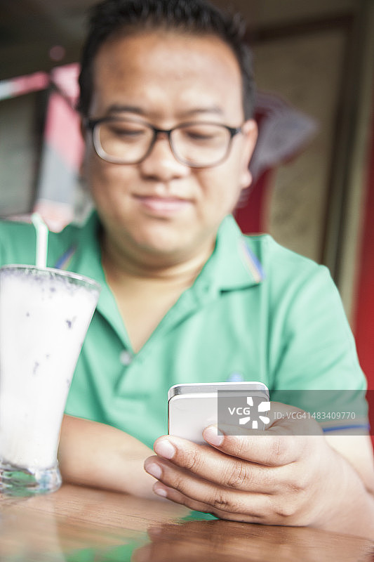 技术：使用智能手机的印度男子图片素材