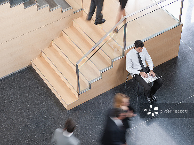 在繁忙办公室走廊工作的商人图片素材