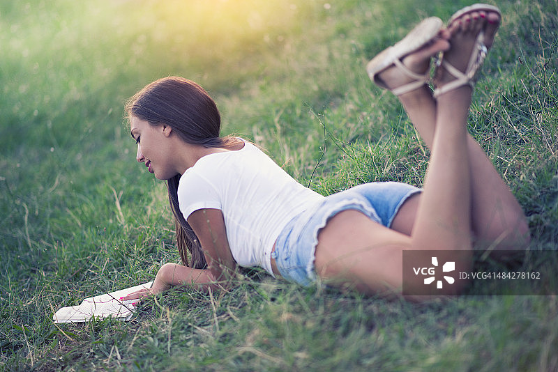 在自然中阅读书籍的年轻黑发女子图片素材