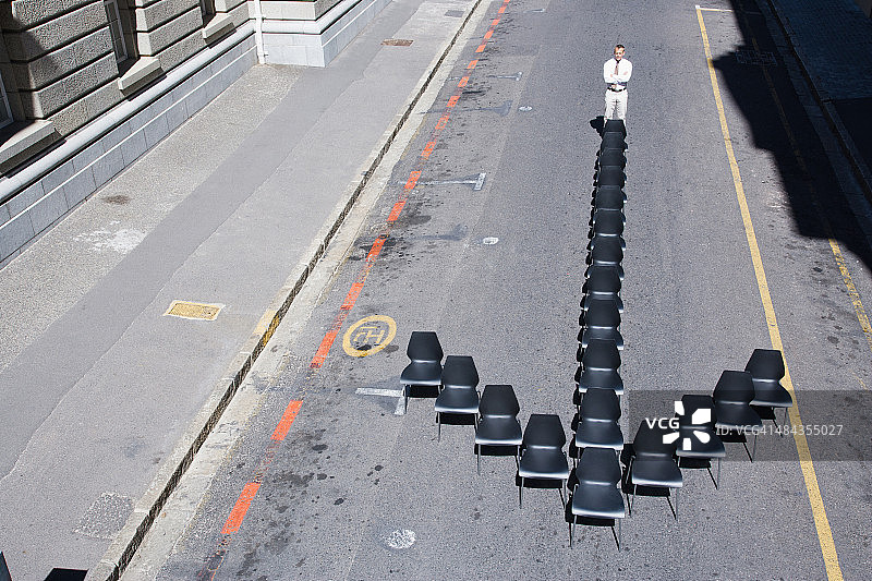 站在箭头形状办公椅上的商人图片素材