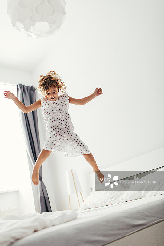 在床上跳跃的小女孩图片素材