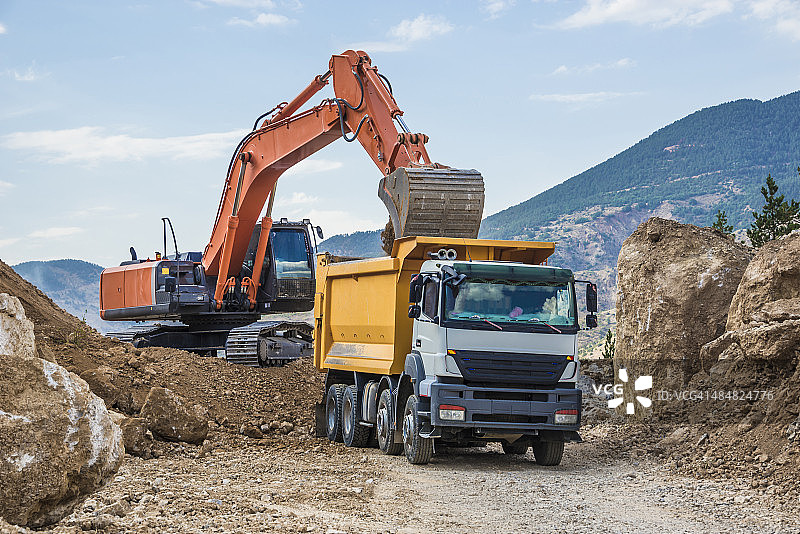 挖掘机装载自卸卡车图片素材