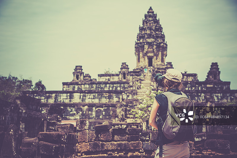 女摄影师在柬埔寨巴孔寺拍照图片素材
