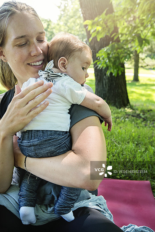 夏天，妈妈在户外帮宝宝拍嗝图片素材