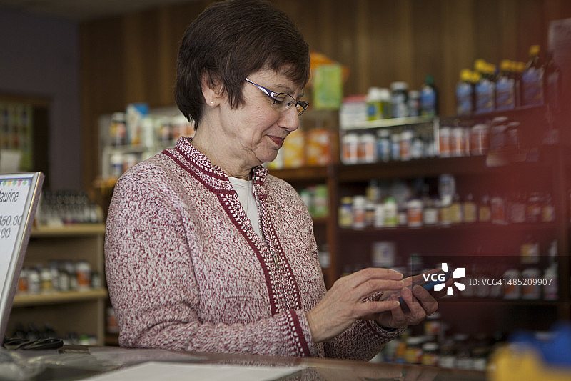 保健食品店老板使用智能手机图片素材
