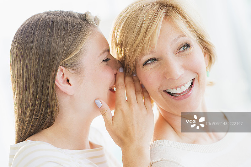 成年女儿在母亲耳边低语图片素材