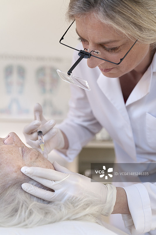 替代疗法医师为年长女性进行针灸图片素材