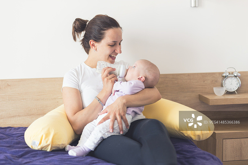 母亲用奶瓶喂宝宝图片素材
