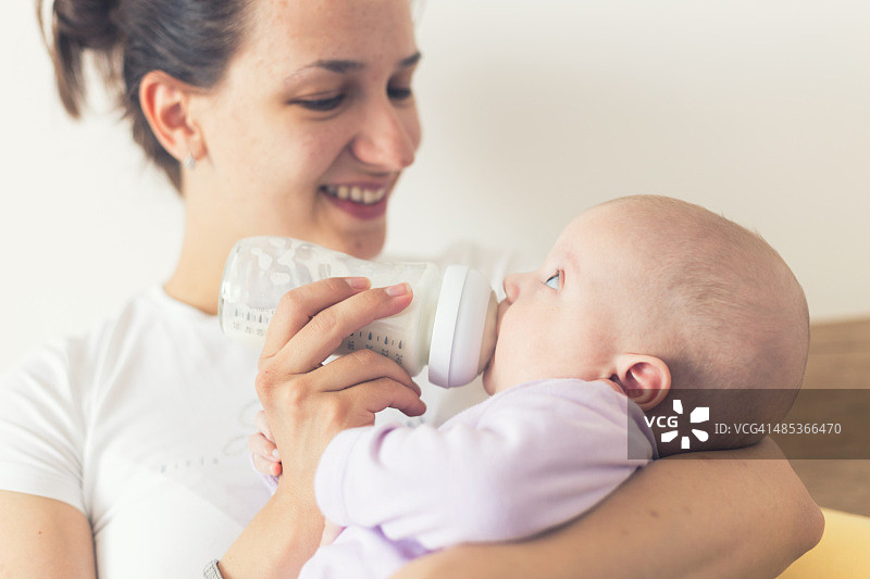 母亲用奶瓶喂宝宝图片素材