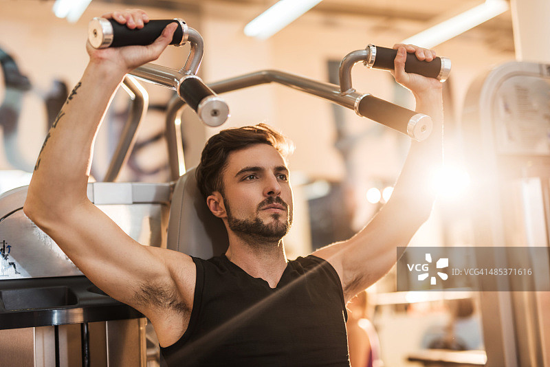 在健身俱乐部做健美运动的运动型男人图片素材