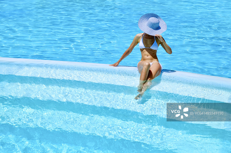 女人在度假村游泳池放松图片素材