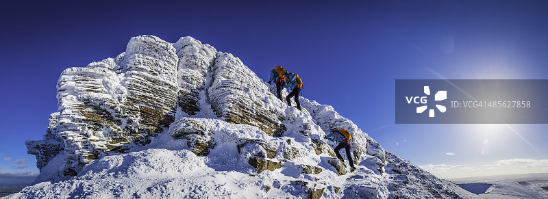 青少年登山者攀登雪山顶峰多重曝光全景冬季阳光图片素材