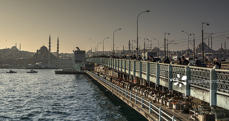 在伊斯坦布尔的加拉塔大桥上工作的渔民图片素材