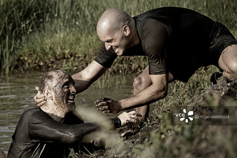 男人们在泥地赛跑中玩耍图片素材