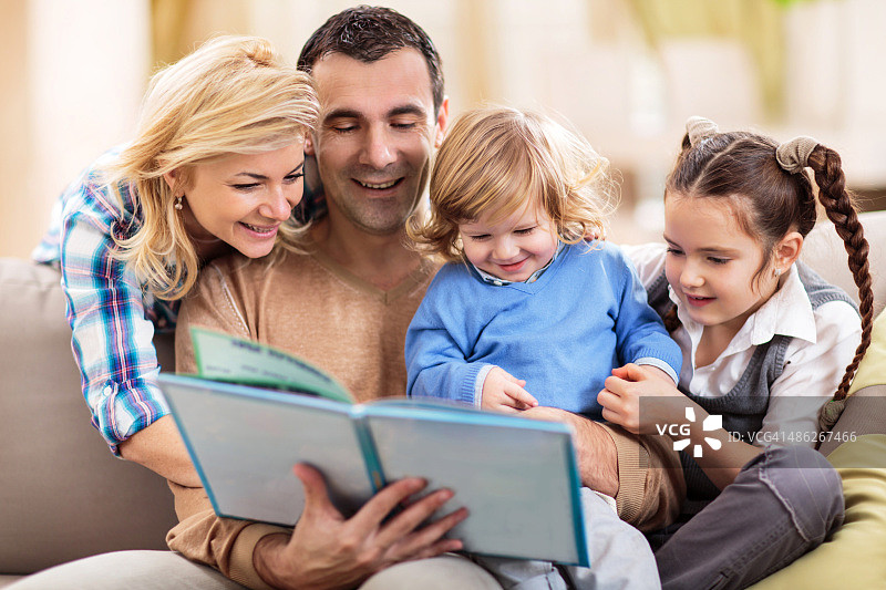 微笑的一家人在家阅读故事图片素材