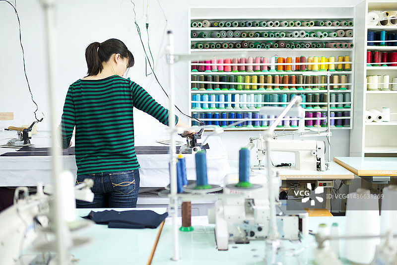 服装设计师在工作台上熨烫面料图片素材