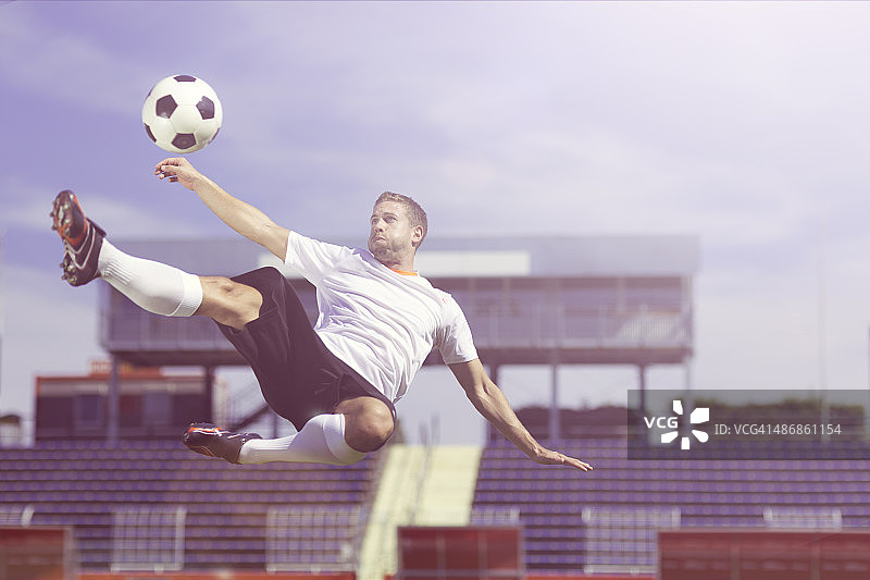 现代足球运动员自行车踢球图片素材