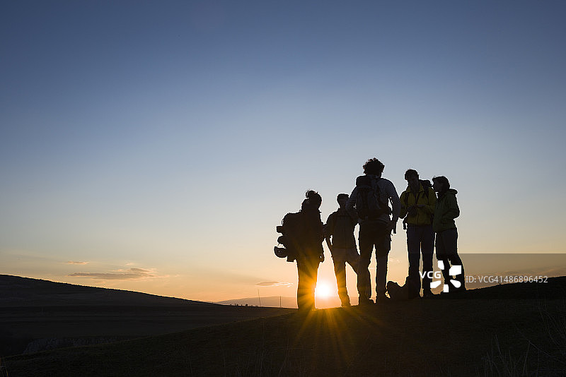 日出时分背着背包的朋友们图片素材