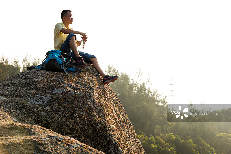 坐在壁架上的男性背包客图片素材