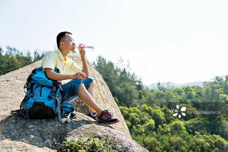 坐在壁架上的男性背包客图片素材