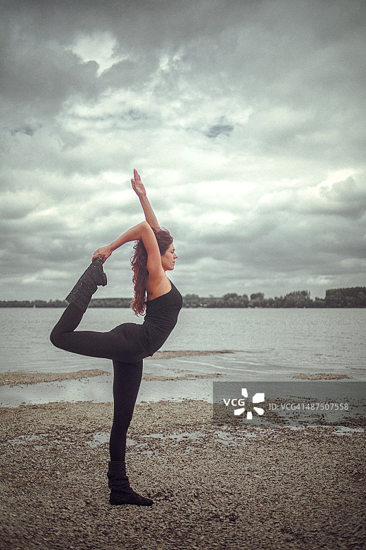 年轻女子在自然中练习Natarajasana瑜伽体式图片素材