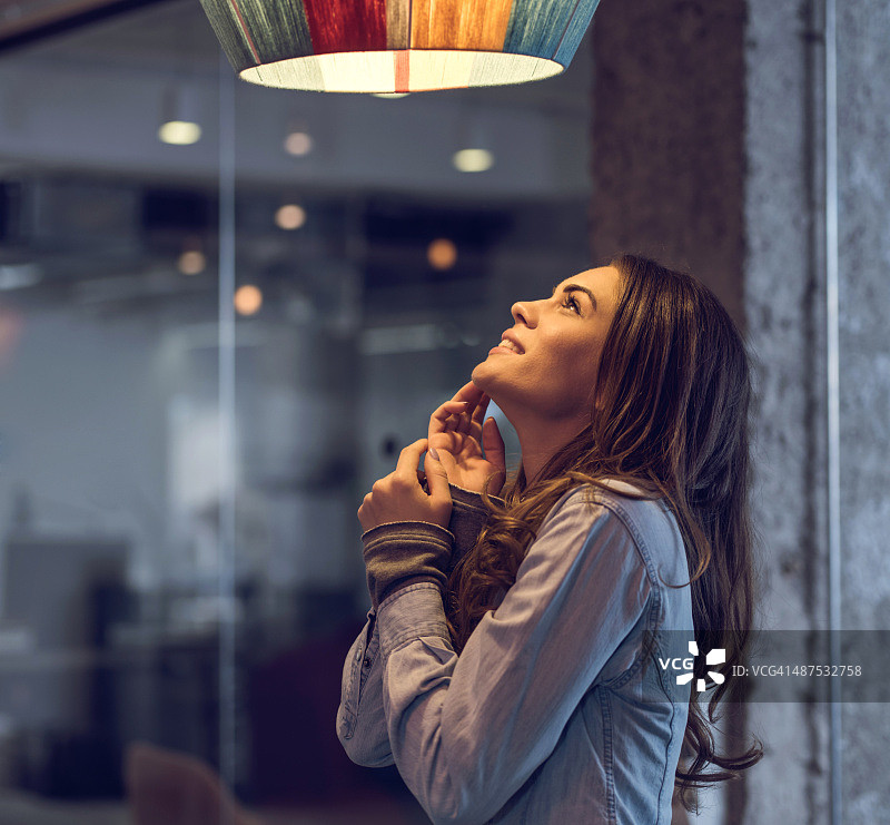 年轻女子站着看着灯图片素材