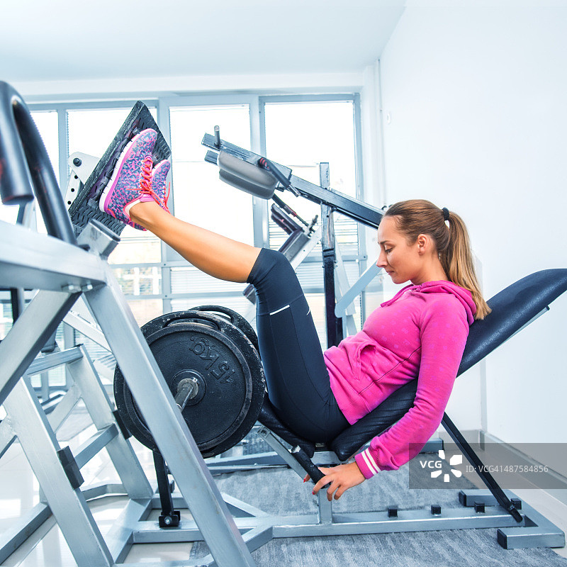 在健身房做腿举的女人图片素材
