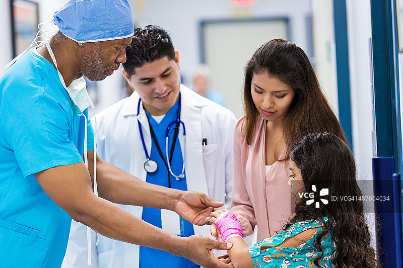 外科医生与儿科患者及医生讨论手腕骨折图片素材