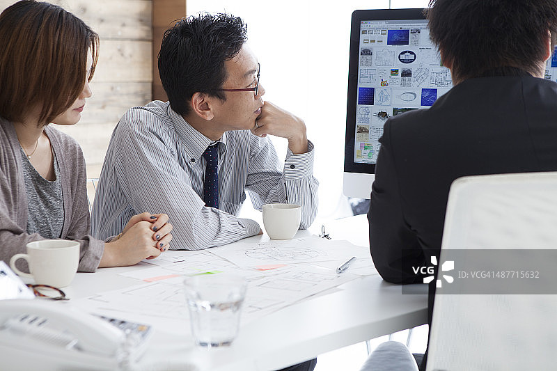 快乐的年轻夫妇在办公室与顾问讨论图片素材