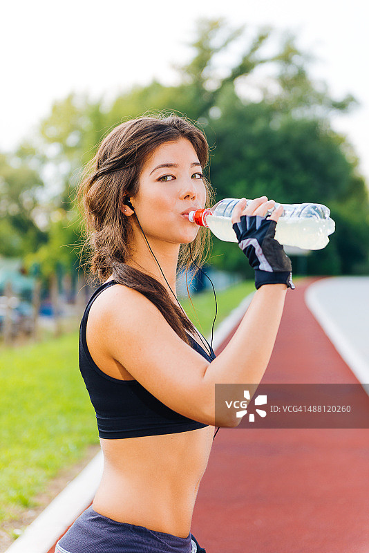 年轻运动员户外交叉训练后喝饮料图片素材