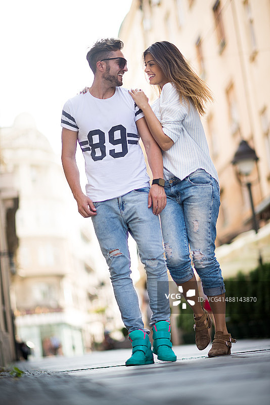 在城市街道上散步的休闲年轻情侣图片素材