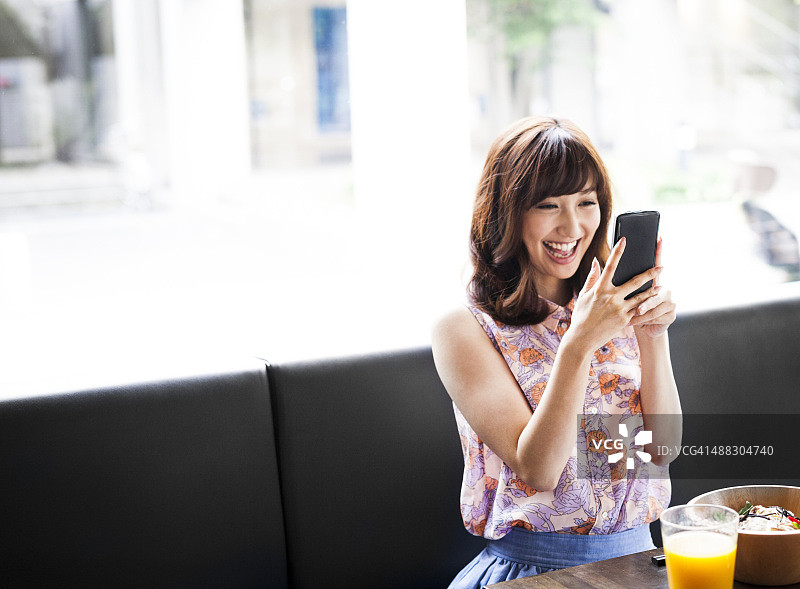 用智能手机吃午餐的快乐女孩图片素材