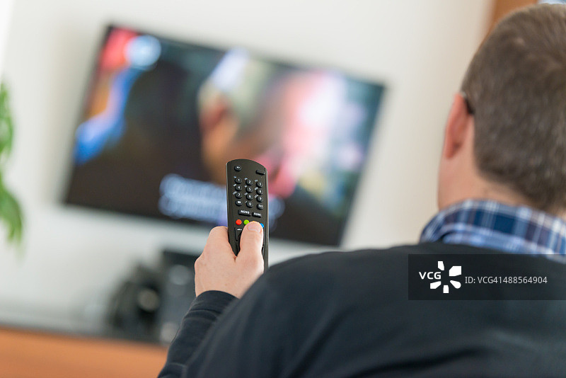 使用电视遥控器的男人图片素材