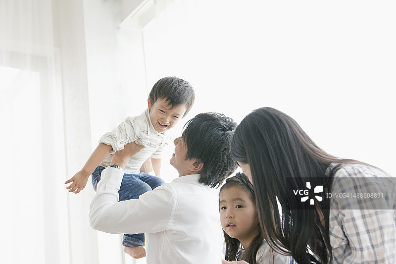 在房间里玩耍的年轻父母和孩子图片素材