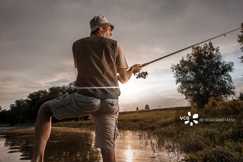 渔夫抛竿钓鱼的背影图片素材