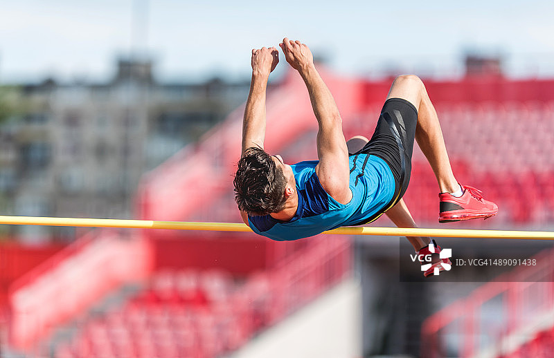 在比赛中进行跳高运动的健壮男人图片素材