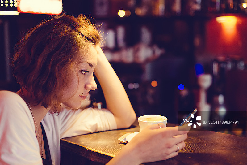 少女在咖啡馆使用智能手机图片素材