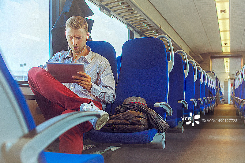 年轻帅气的男人在上班途中使用数字平板电脑图片素材