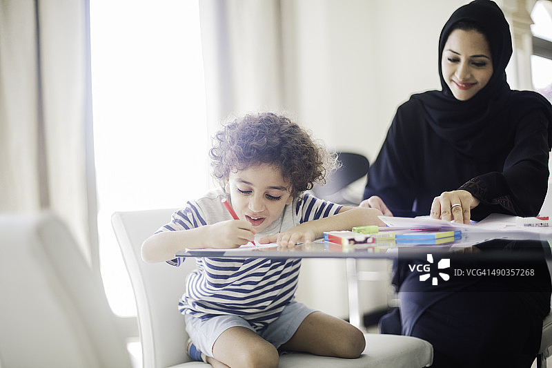 中东母亲辅导孩子做作业图片素材