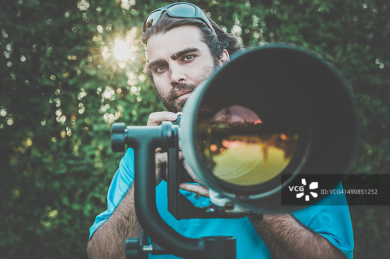 使用超长焦镜头的男摄影师图片素材