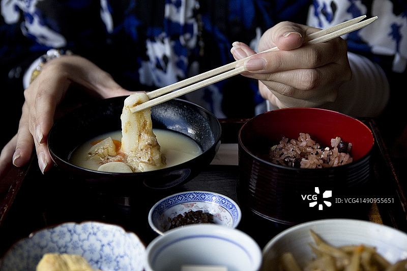 女人喝杂煮年糕汤图片素材