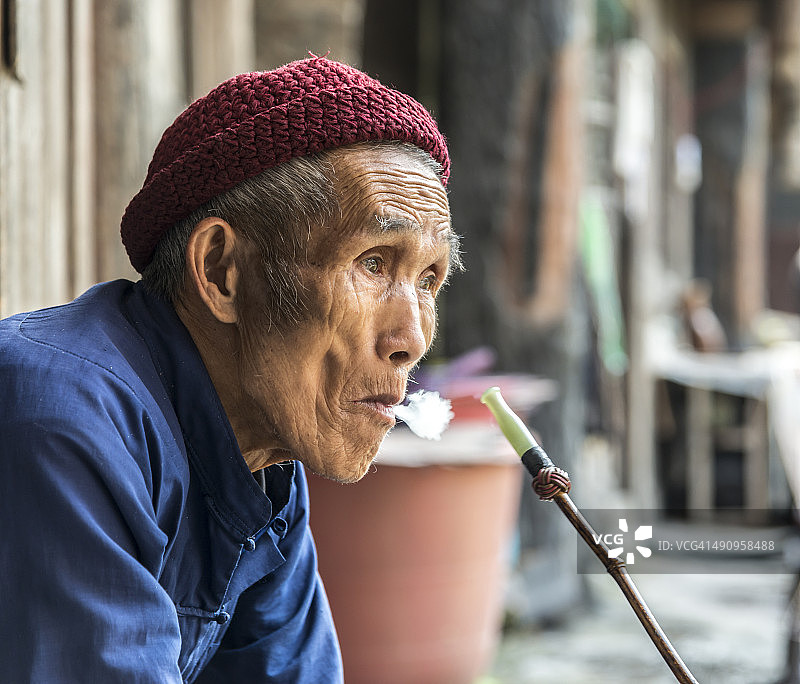 抽烟斗沉思的中国老人图片素材