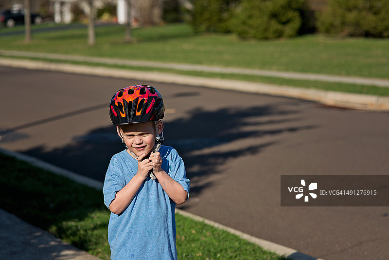 男孩戴上自行车头盔图片素材
